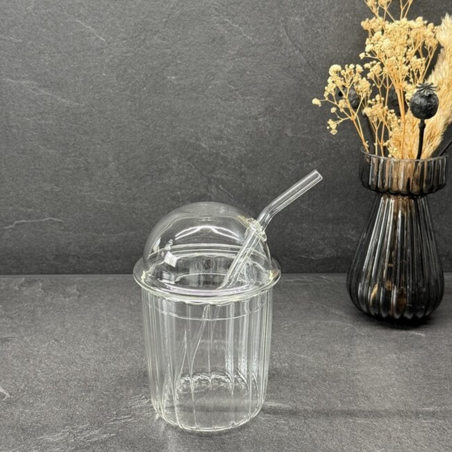 Gewölbter Glasbecher mit Strohhalm